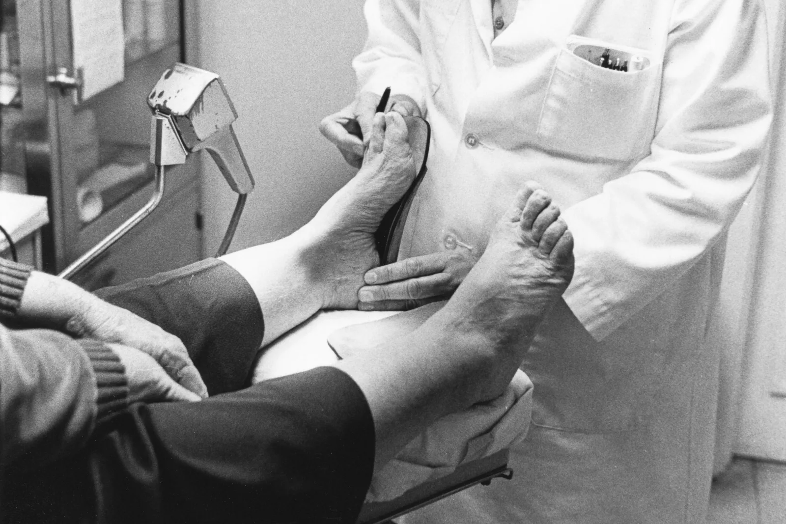 Doctor examining a patient's bare foot and ankle